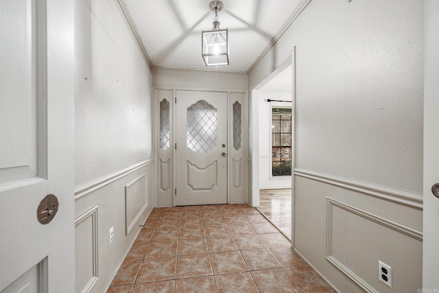 tiled entryway featuring crown molding