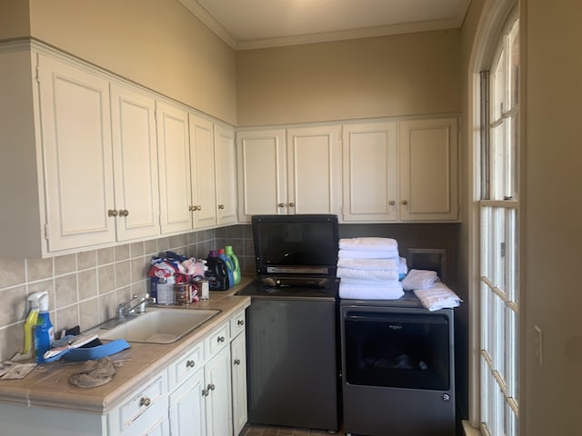 washroom featuring separate washer and dryer, sink, and ornamental molding