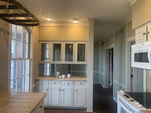 kitchen with white cabinetry, white appliances, tile countertops, and ornamental molding