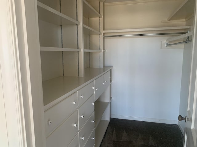 spacious closet featuring dark carpet