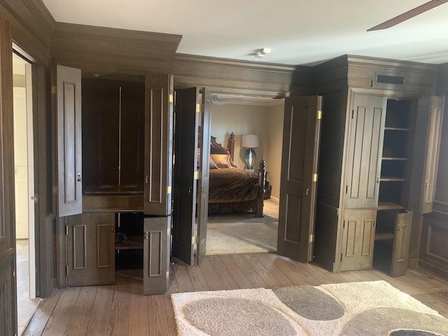 interior space featuring ornamental molding and light wood-type flooring