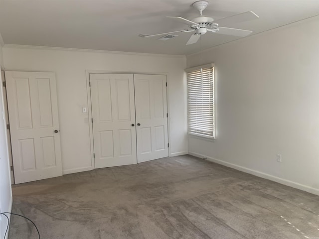 unfurnished bedroom featuring crown molding, light colored carpet, a closet, and ceiling fan