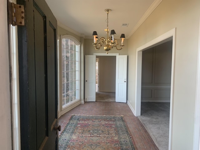 corridor with ornamental molding and a notable chandelier