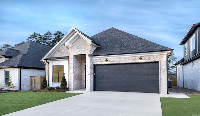 french country home with a garage, central AC, and a front lawn