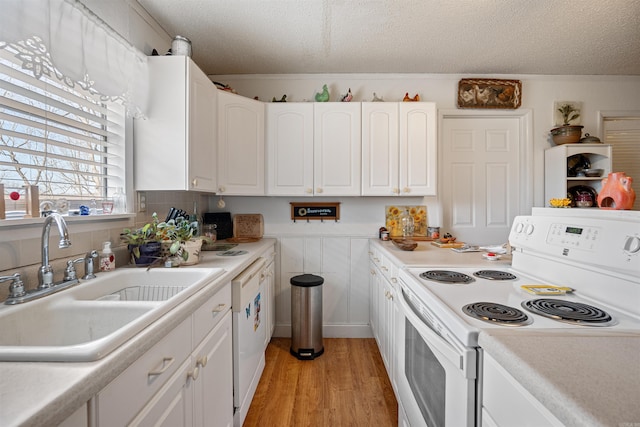 kitchen with white cabinetry, sink, a textured ceiling, and white range with electric cooktop