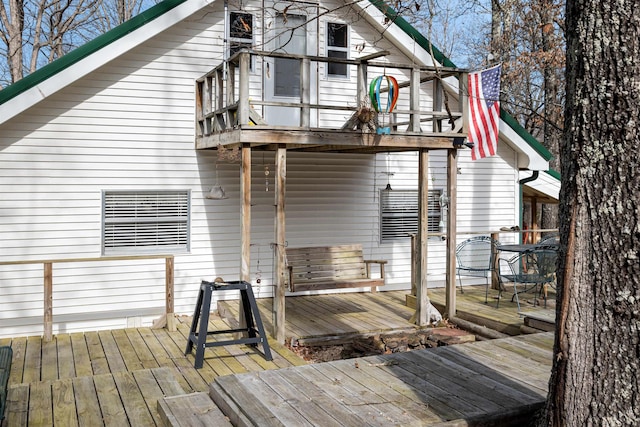 rear view of house featuring a balcony and a deck