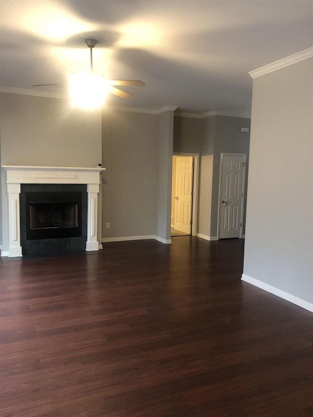 unfurnished living room featuring dark hardwood / wood-style flooring, ornamental molding, ceiling fan, and a fireplace