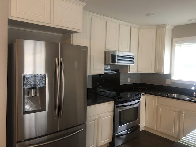 kitchen with sink, backsplash, stainless steel appliances, and dark tile patterned floors