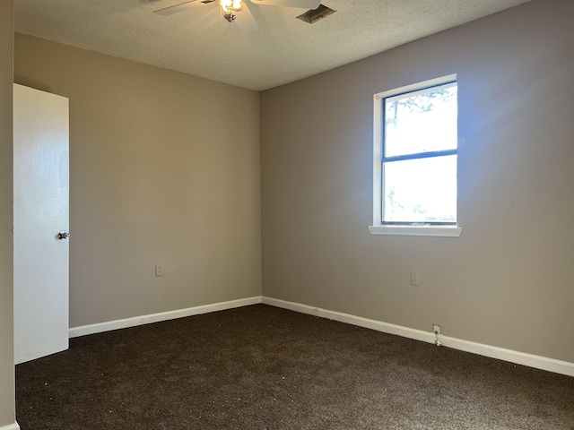 unfurnished room with dark colored carpet, ceiling fan, and a textured ceiling