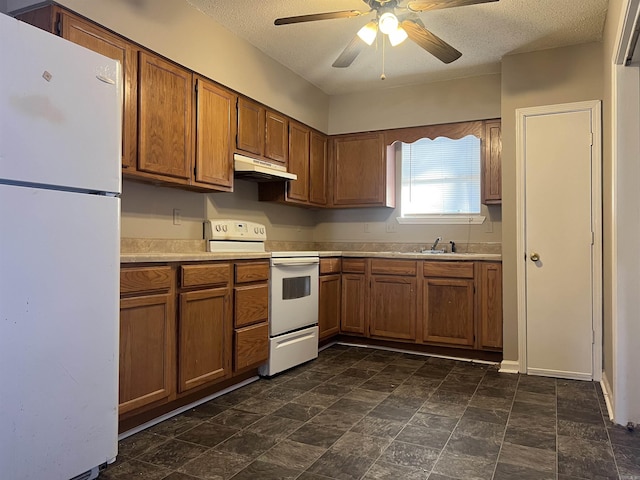 kitchen featuring ceiling fan, white appliances, sink, and a textured ceiling