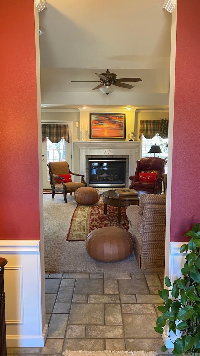 living room featuring a tiled fireplace and ceiling fan