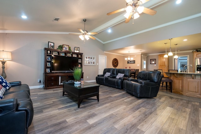 living room featuring hardwood / wood-style flooring, vaulted ceiling, and ornamental molding