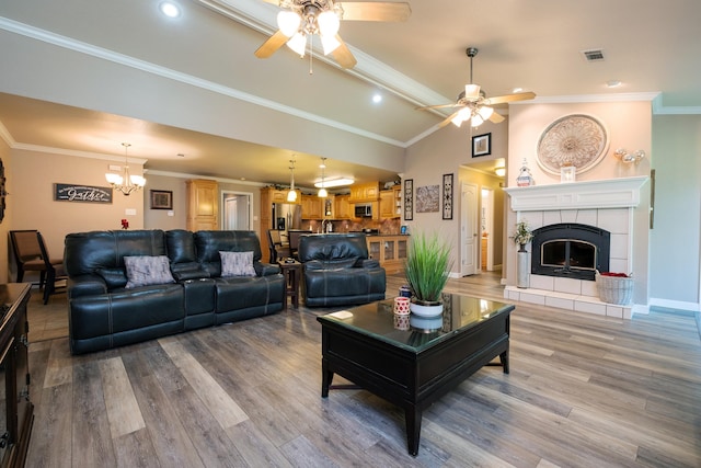 living room featuring a fireplace, ornamental molding, and wood-type flooring