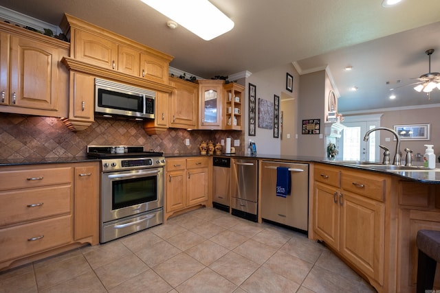 kitchen with appliances with stainless steel finishes, sink, decorative backsplash, ornamental molding, and light tile patterned floors