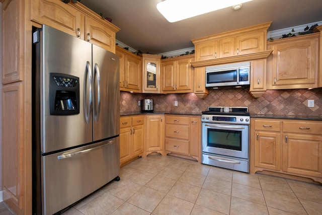 kitchen featuring crown molding, stainless steel appliances, light tile patterned floors, and backsplash