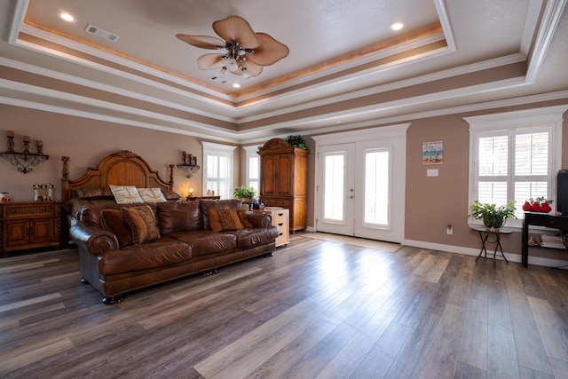 bedroom featuring dark wood-type flooring, ornamental molding, a raised ceiling, access to outside, and french doors