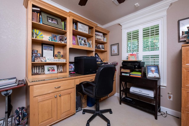 office space featuring ornamental molding, built in desk, and light carpet