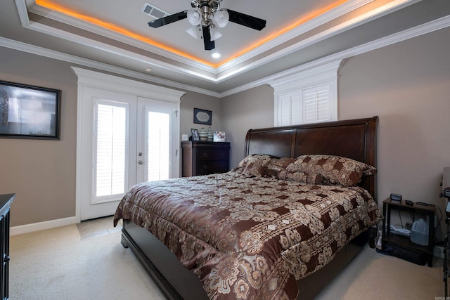 bedroom featuring ornamental molding, light colored carpet, access to exterior, ceiling fan, and a tray ceiling