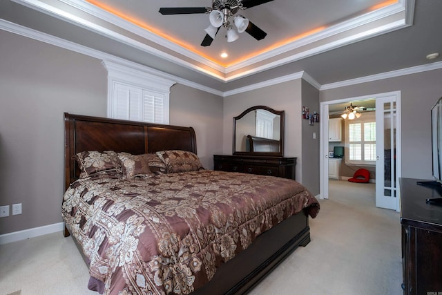 bedroom with light carpet, ornamental molding, a raised ceiling, and ceiling fan