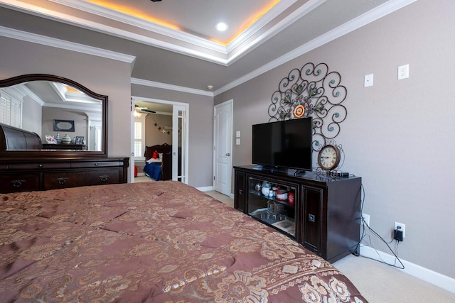 carpeted bedroom featuring ornamental molding and a tray ceiling