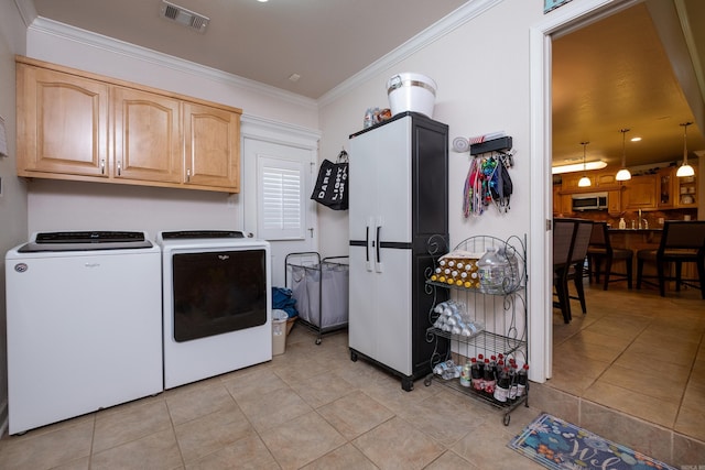 laundry area featuring cabinets, ornamental molding, washer and dryer, and light tile patterned flooring