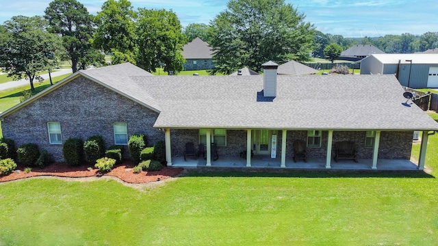 back of property with a yard and a patio area