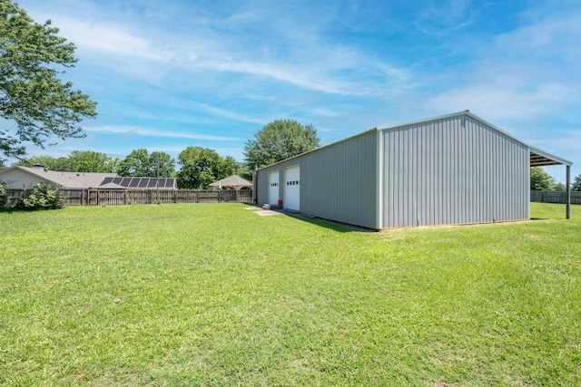 view of yard featuring a garage and an outbuilding