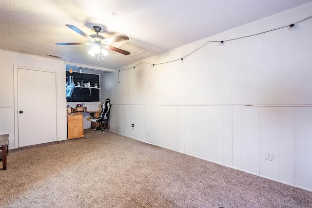 unfurnished bedroom with ceiling fan, carpet, and a textured ceiling