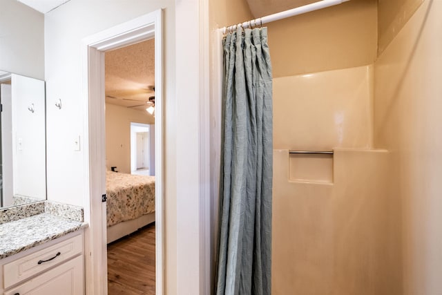 bathroom with ceiling fan, vanity, curtained shower, and wood-type flooring