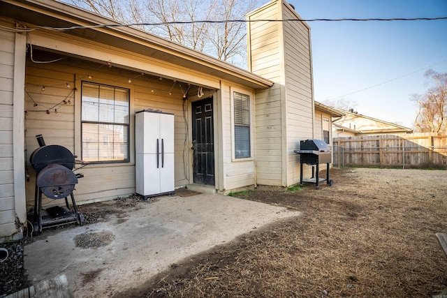 view of exterior entry with a patio area