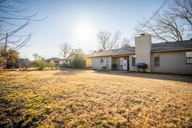 rear view of house featuring a lawn