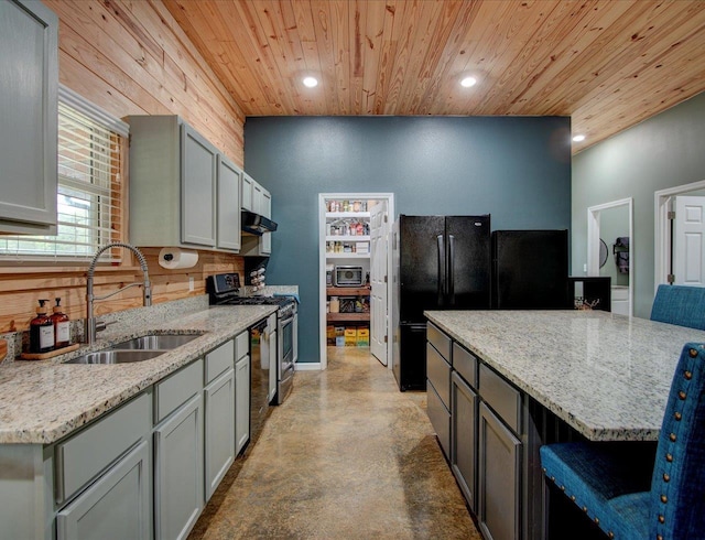 kitchen with sink, a kitchen bar, light stone counters, gas range, and wooden ceiling