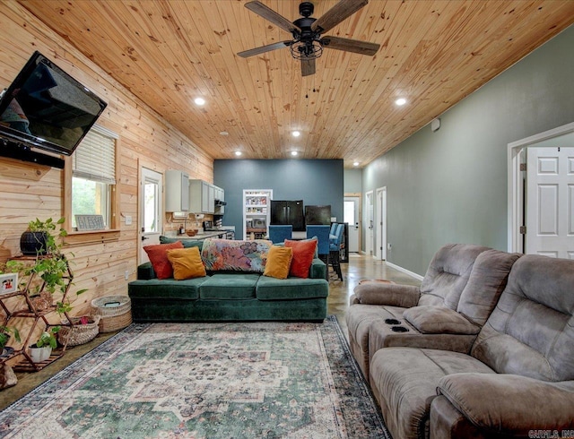 living room featuring wooden ceiling, ceiling fan, and wood walls