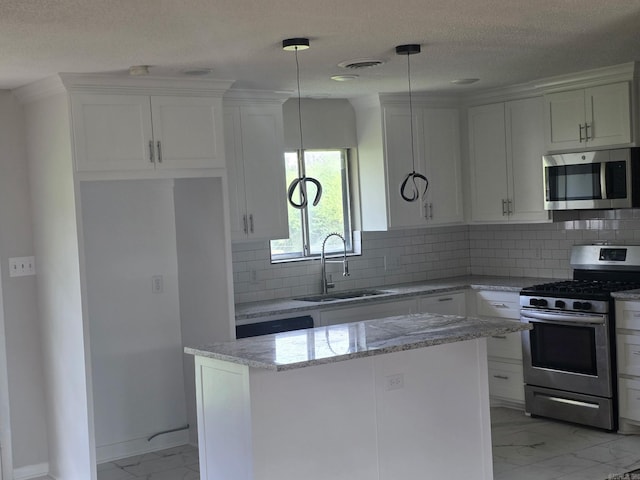 kitchen featuring a sink, marble finish floor, white cabinets, a kitchen island, and appliances with stainless steel finishes