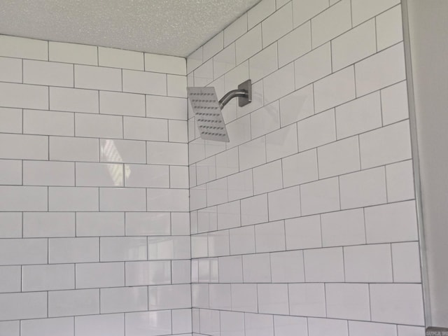 details with tiled shower and a textured ceiling