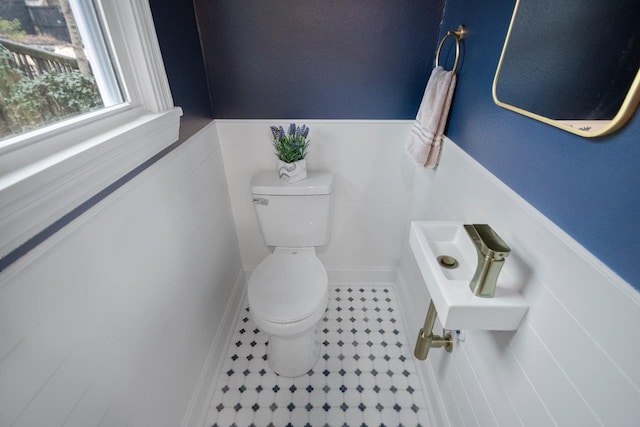 bathroom featuring tile walls and toilet