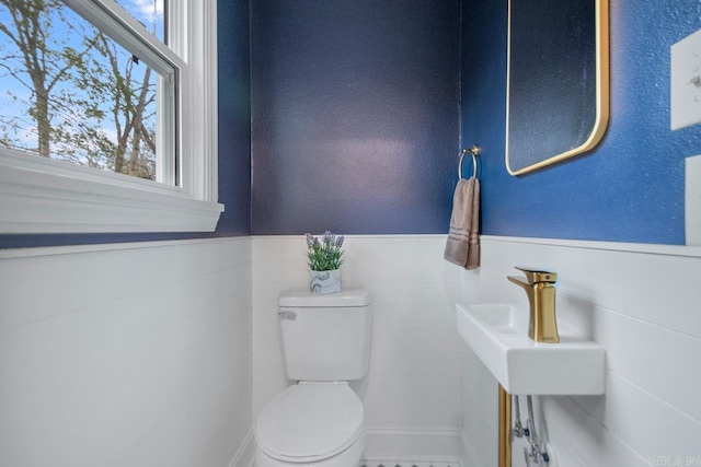 bathroom with tile walls and toilet