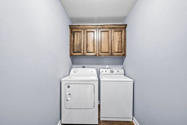 washroom with cabinets and washer and dryer