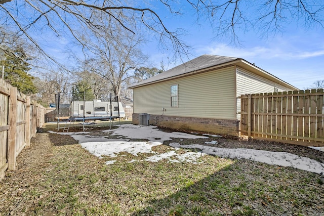 view of home's exterior featuring a trampoline, cooling unit, and a lawn