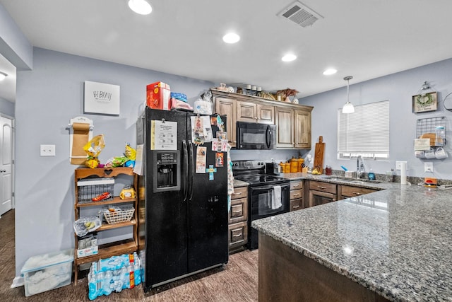 kitchen with sink, stone countertops, dark hardwood / wood-style floors, kitchen peninsula, and black appliances