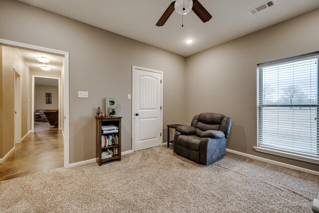 living area featuring ceiling fan and light carpet