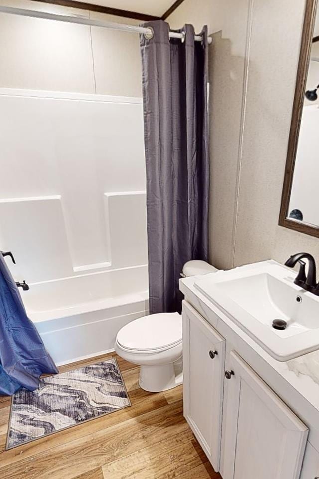 full bathroom with vanity, wood finished floors, toilet, and shower / bath combination with curtain