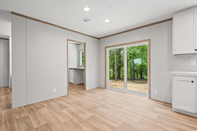 unfurnished living room featuring light wood-style flooring, crown molding, and recessed lighting