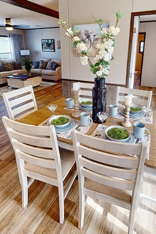 dining room with a ceiling fan, light wood-style floors, and beamed ceiling