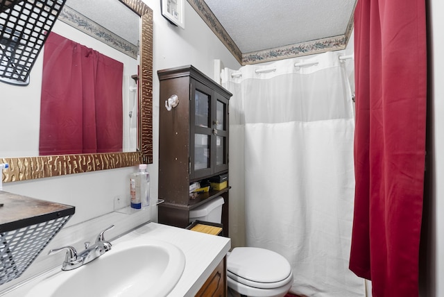 bathroom with vanity, toilet, and a textured ceiling