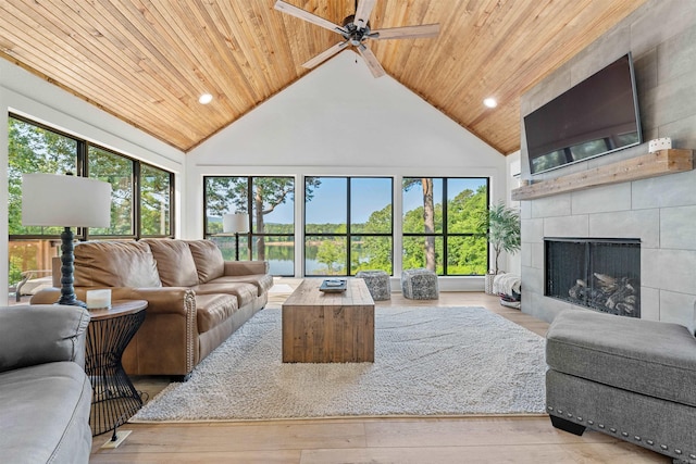 living room featuring high vaulted ceiling, wood ceiling, a fireplace, and light hardwood / wood-style floors