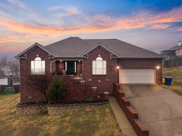 ranch-style home with a garage and a lawn