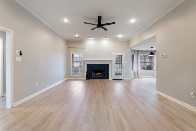 unfurnished living room with ceiling fan, ornamental molding, and light wood-type flooring