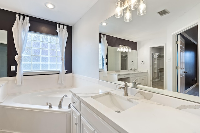 bathroom featuring a washtub, vanity, and a notable chandelier