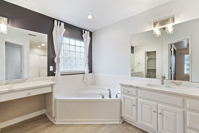 bathroom with vanity, wood-type flooring, plus walk in shower, and an inviting chandelier